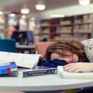 Picture of student asleep on books